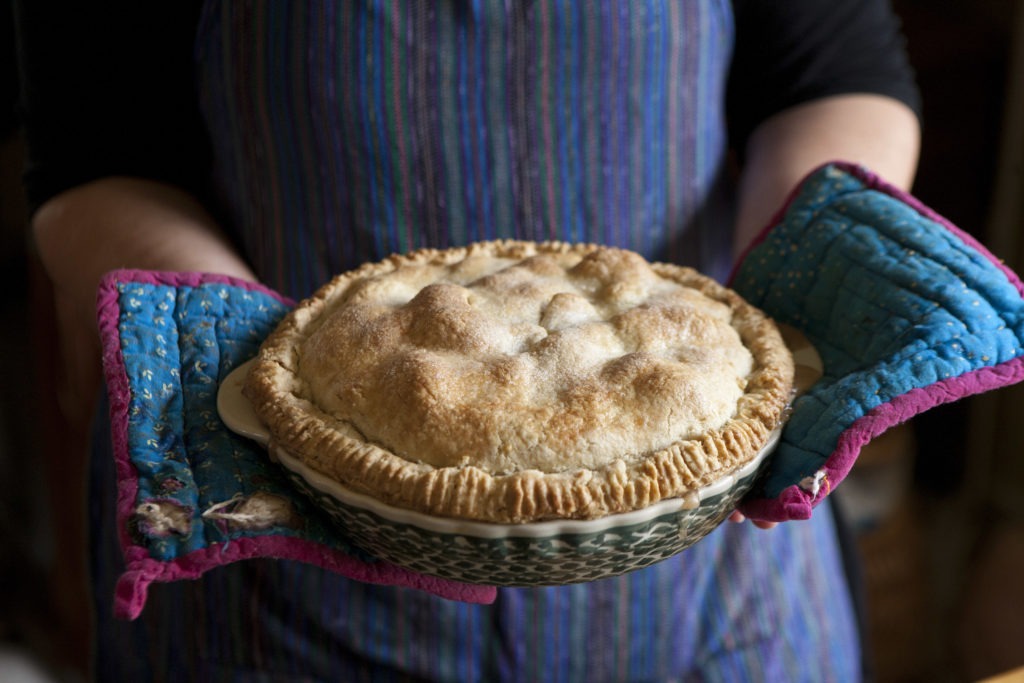Kate McDermott of the Art of the Pie holding a deep dish apple pie